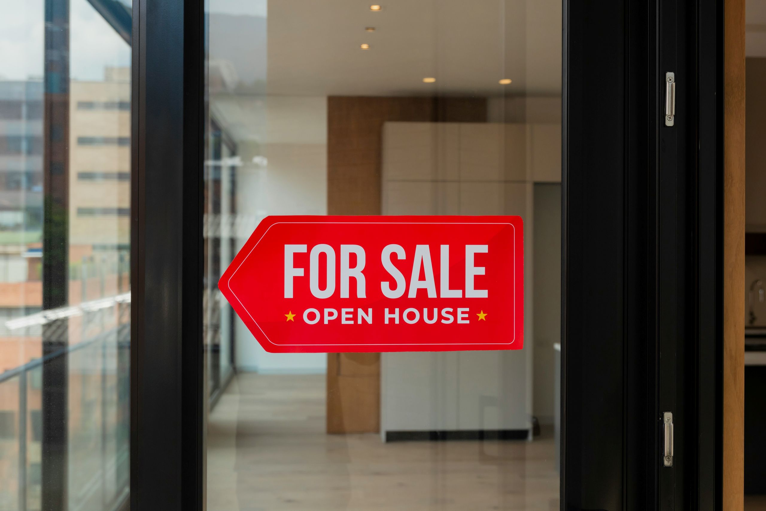 prepare your home A red For Sale, Open House sign is stuck to a glass door.